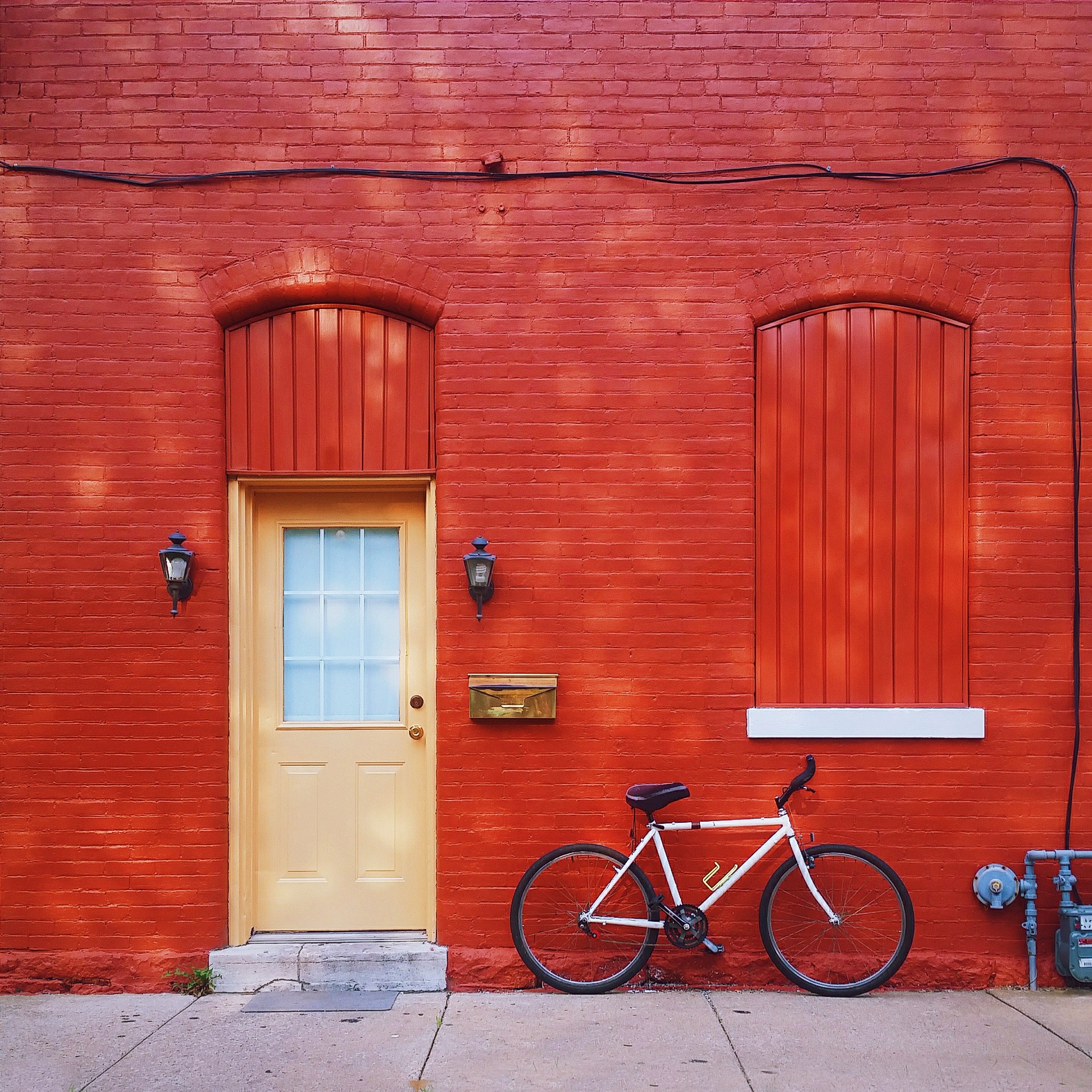 white road bicycle beside red wall paint building photography